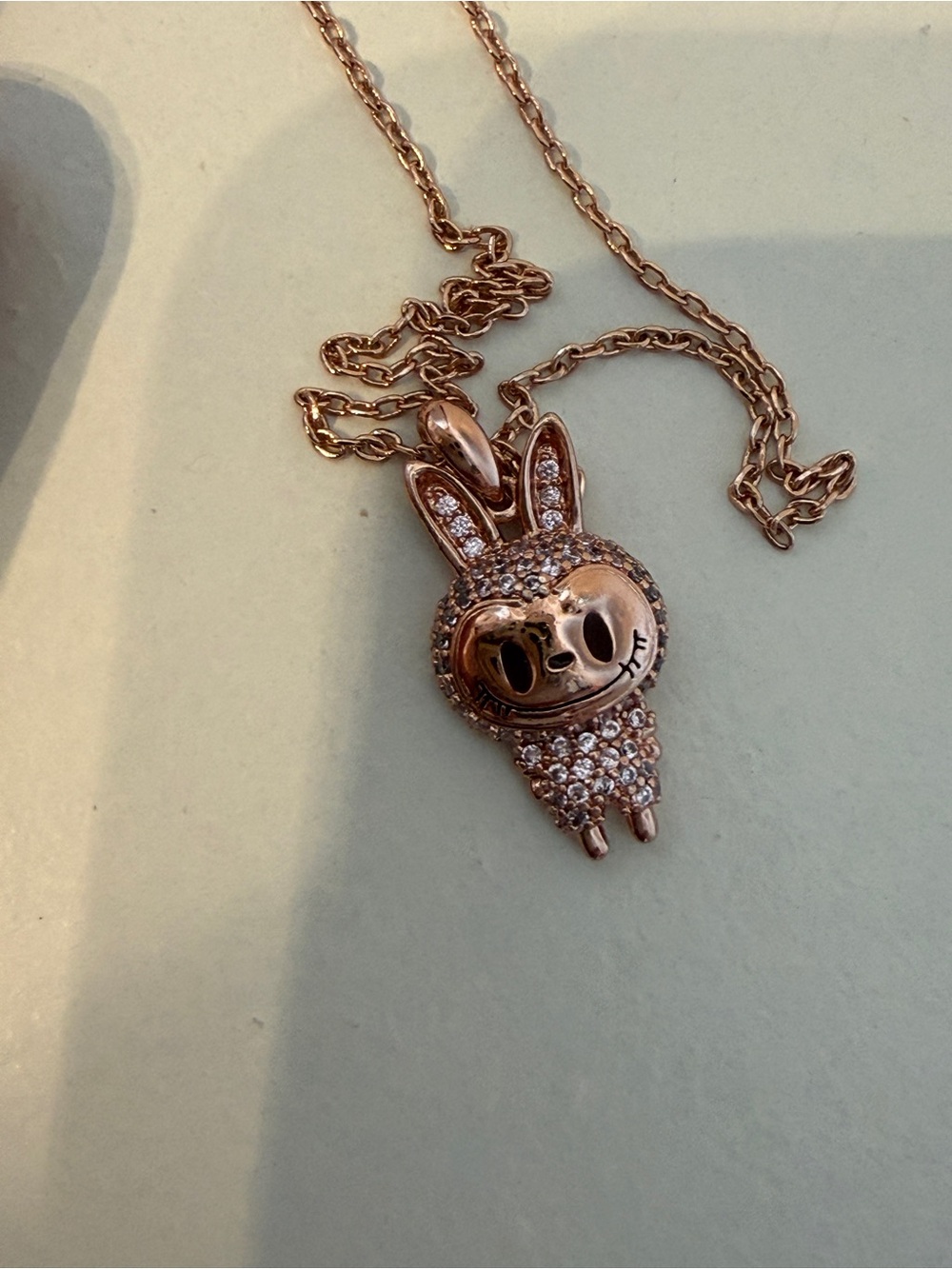 rose gold-toned Labubu monster pendant necklace featuring clear pavé stones
